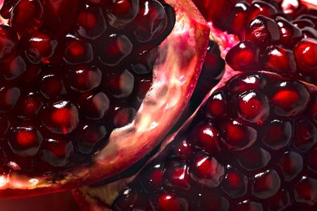 Delicious beautiful pomegranate on dark background. Close-up image of a red pomegranate