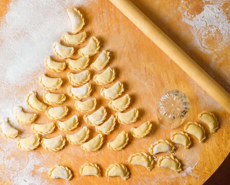 Beautiful delicious dumplings on a wooden Board laid out in the form of a Christmas tree, cooked at...