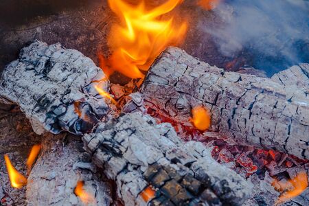 Burning coals from logs on the fire. The wind blows the burning fire.の写真素材