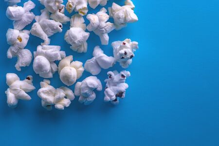 Popcorn on a blue background. Macro image of popcorn. Place for your text.の写真素材
