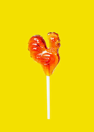 Pastel yellow. Lollipop red cockerel on a stickの写真素材