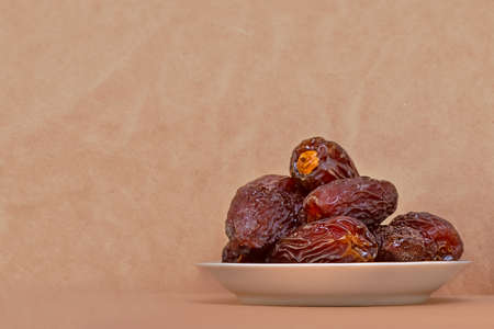 The Concept Of Ramadan. Dates in a plate on a light beige background