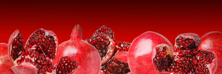 Juicy bright shiny pomegranate seeds on a red backgroundの写真素材