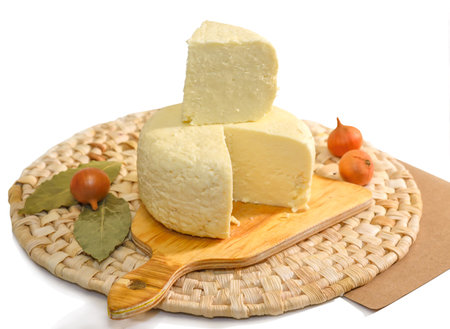 Round cut Adyghe cheese on a woven napkin on a white backgroundの写真素材