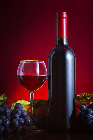 Wine. Bottle and glass of red wine with ripe grapes still life. Red wine.の写真素材