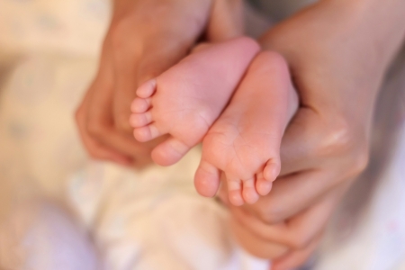 A parent s hands tenderly hold their newborn s feet の写真素材