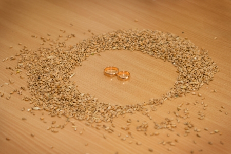 Wedding rings in wheat on the desktopの写真素材