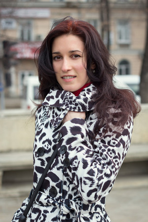 Cheerful tourist girl in casual clothes walking through streetの写真素材