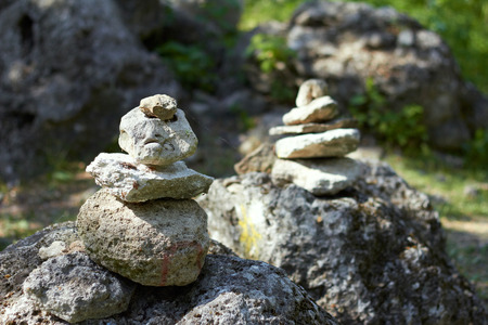 Stack of pebble stones by a stream in a forest