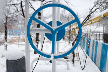 Landscape of the winter yard, against the background of a blue well drum, it snowsの写真素材