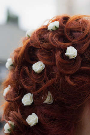 Festive hairstyle, hair beautifully and gently laid with jewelry in the form of white roses