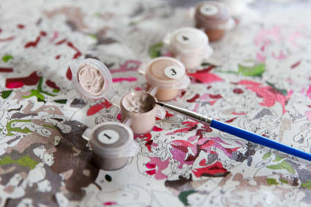 Picture by number. Creative process of painting a picture with multicolored acrylic colors at home