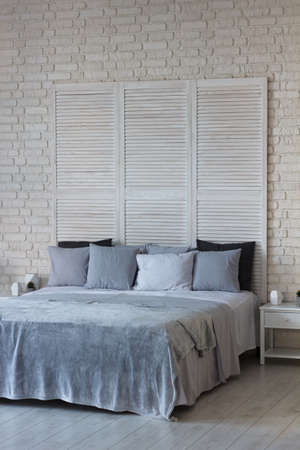 Gentle interior of bedroom is in light colors, there is a bed with pillows and a covering. Great usual place to sleepの写真素材