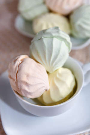 Delicious sweet fresh multicolored air marshmallow lies on a serviced table in saucersの写真素材