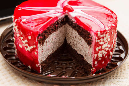 Cut Cherry cake, a delicious, sweet confection with red white glaze, white chocolate crumbs and...