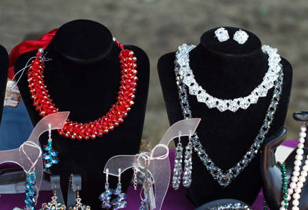 Red and white beautiful necklace accessory on a rack at the exhibition and saleの写真素材