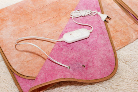 A warm two-sided electric sheet, lies assembled, and on top of sheet lie a temperature switch. This is a quick and economical way to heat up in cold season, in winterの写真素材
