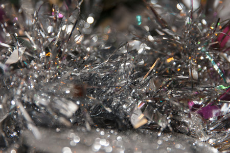 Close-up of shiny silver tinsel with colorful accents. Scene captures the festive spirit, ideal for holiday decorations and celebrationsの写真素材