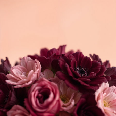 A close-up of a bouquet featuring pink and burgundy flowers. Arrangement includes various blooms with soft petals against a light backgroundの素材