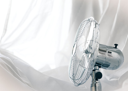 relax concept - metal fan near the window (small grip)の写真素材