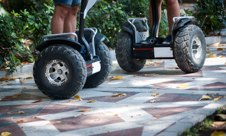 Bottom part of individual electric scooters that are being drived by tourists in the park