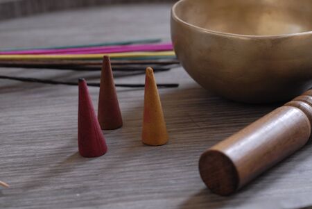 tibetan bell, incense stick, and cones, multicolored, with wooden backgroundの写真素材