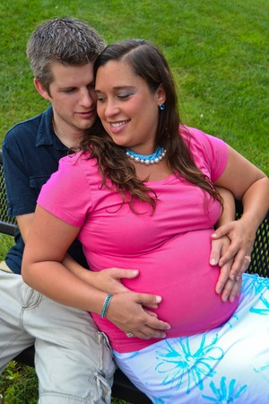 Expectant Couple Sitting on a Park Benchの写真素材