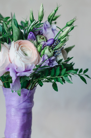 Pastel colors wedding bouquet made of violet and white ranunculus, lavender, eucalyptus, freesia, cloves and limonium flowers on a white background, holiday and bride floristic. Bridal flowers. Bouquet of bride. Marriageの写真素材