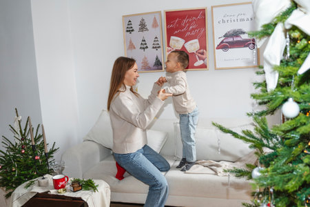 Mother and Son Celebrating Christmas Near a Decorated Treeの写真素材
