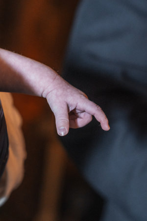 A baby's hand being held, possibly during a religious ceremony.の写真素材