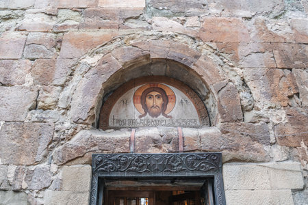An ancient Orthodox church with stone walls and an icon of Christ above the entrance. An atmosphere of spirituality and history.の写真素材