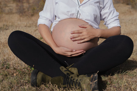 Pregnant Woman in Nature in Autumn, Tender Moment of Expectationの写真素材