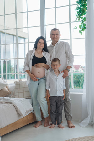 Family pregnancy photoshoot with father, pregnant mother, and sonの写真素材