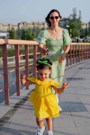 Mother and daughter enjoying a joyful picnic, running in the park, playing by the lake, and having fun in a lavender field. Bright outfits, summer vibes, and heartfelt family moments.の写真素材