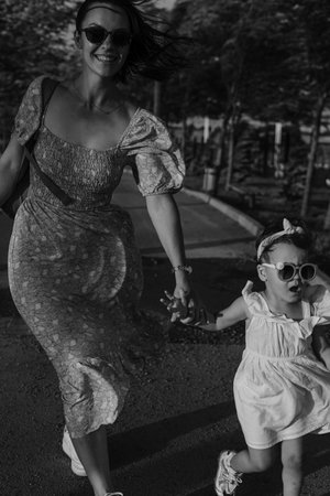 Mother and daughter enjoying a joyful picnic, running in the park, playing by the lake, and having fun in a lavender field. Bright outfits, summer vibes, and heartfelt family moments.の写真素材