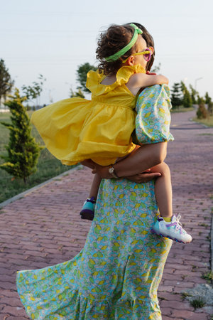 Mother and daughter enjoying a joyful picnic, running in the park, playing by the lake, and having fun in a lavender field. Bright outfits, summer vibes, and heartfelt family moments.の写真素材