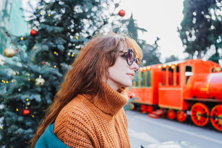 Smiling red-haired woman at a European-style Christmas market during the day, Tbilisi, Georgia