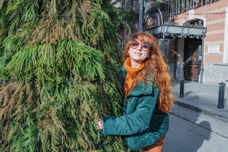 Smiling red-haired woman at a European-style Christmas market during the day, Tbilisi, Georgiaの写真素材