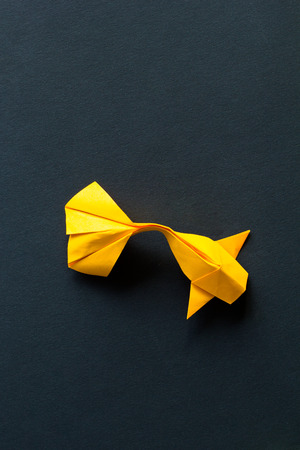 Handmade paper craft origami gold koi carp fish on black background.Top viewの写真素材