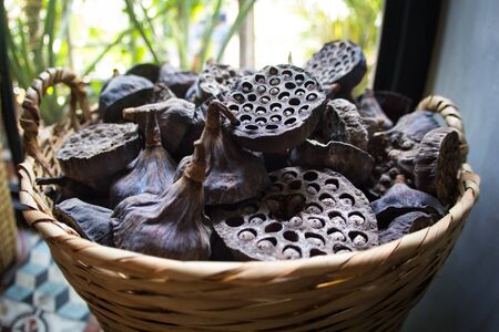Dry old  lotus pods with seeds and empty holes close up for background in wicker basket. Seed stem. Amazing plant design.Partial focusの写真素材