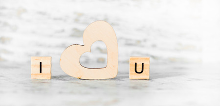 the phrase I love you wooden blocks and a heart on a light wooden backgroundの写真素材