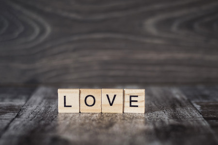 the word love from wooden cubes on a dark wooden backgroundの写真素材