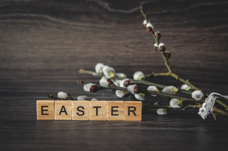 The word Easter is of light wooden panels and willow twigs with the seals on the dark wooden backgroundの写真素材