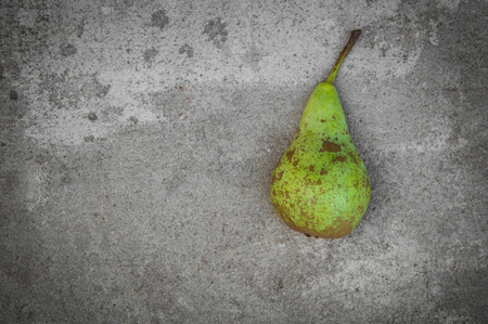 Green mottled pear on grey concrete backgroundの写真素材