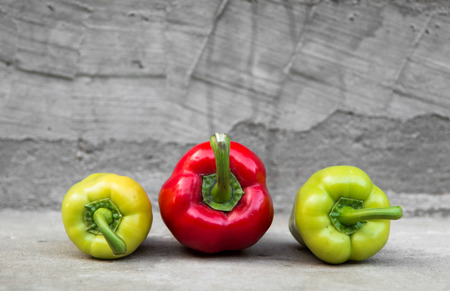 Red and green peppers on grey concrete backgroundの写真素材