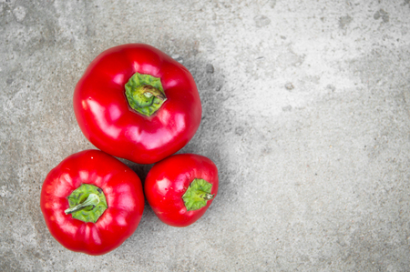 Ripe red peppers on grey concrete backgroundの写真素材