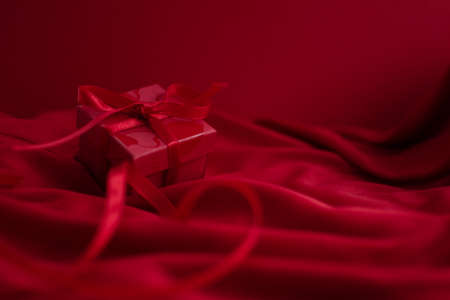 Red gift box on a red background for Valentine's Dayの写真素材