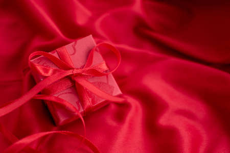 Red gift box on a red background for Valentine's Dayの写真素材