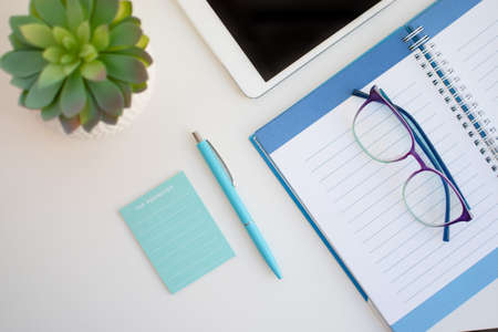High angle view of a desk with writing instruments and sticky notes