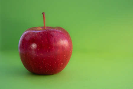Red apple on a green background. Copy space. Horizontal orientation.の写真素材